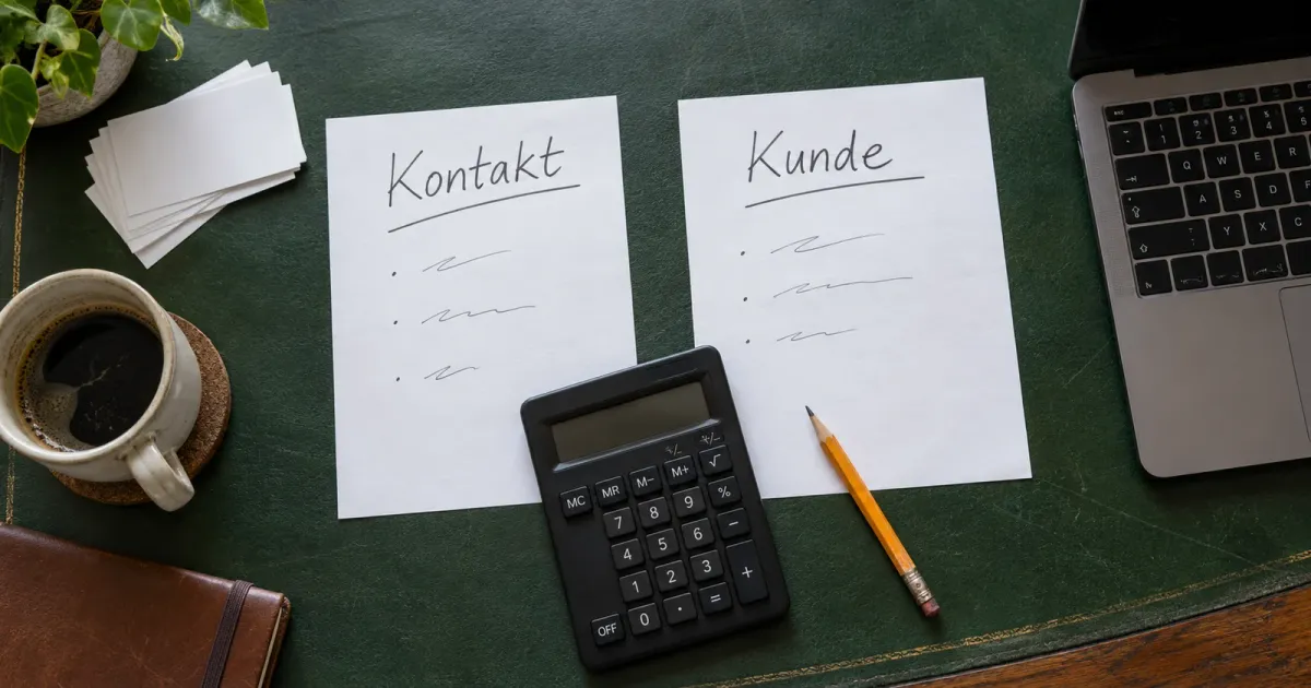 Generierte Tischszene: Notizblätter mit Kontakt und Kunde neben einem Taschenrechner für den Kostenvergleich.
